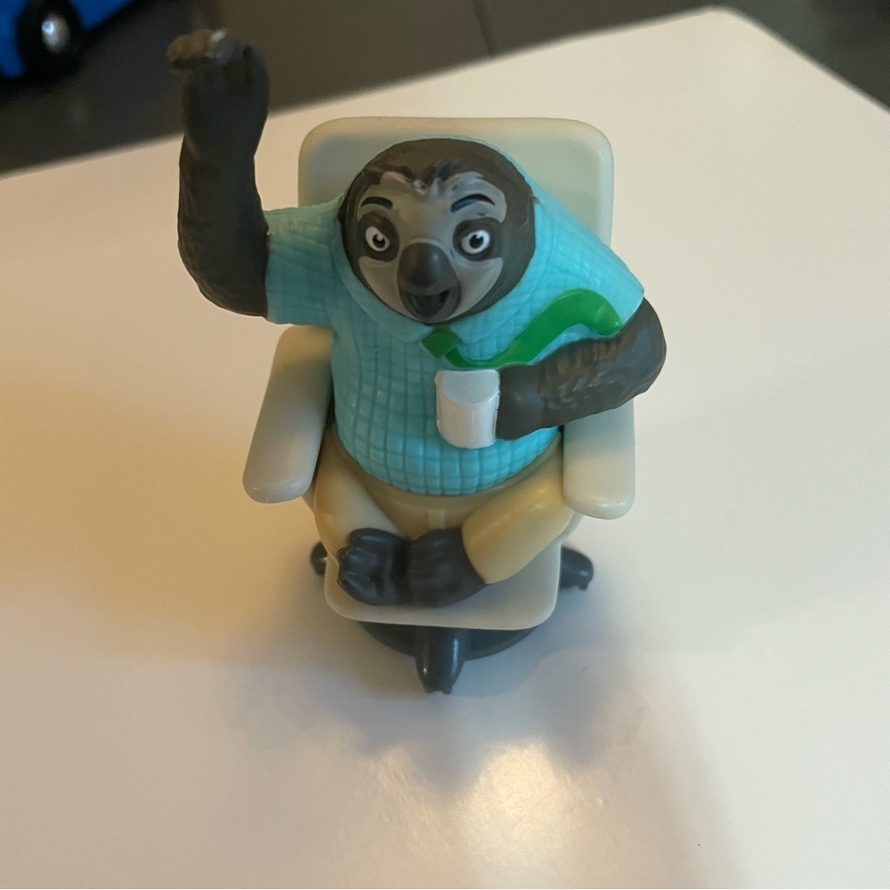 Zootopia 2 Flash the Sloth Figurine Sitting in Beige Chair with Teal Sweater